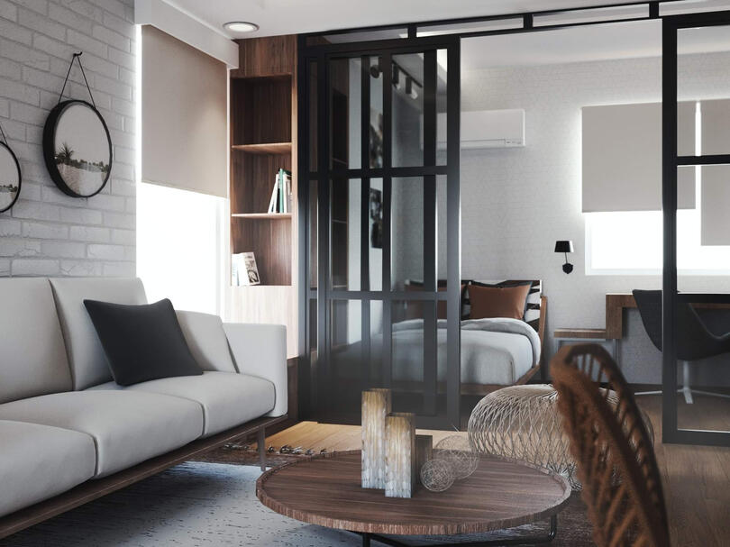 Warm perspective of studio condo with a partitioned faux bedroom.